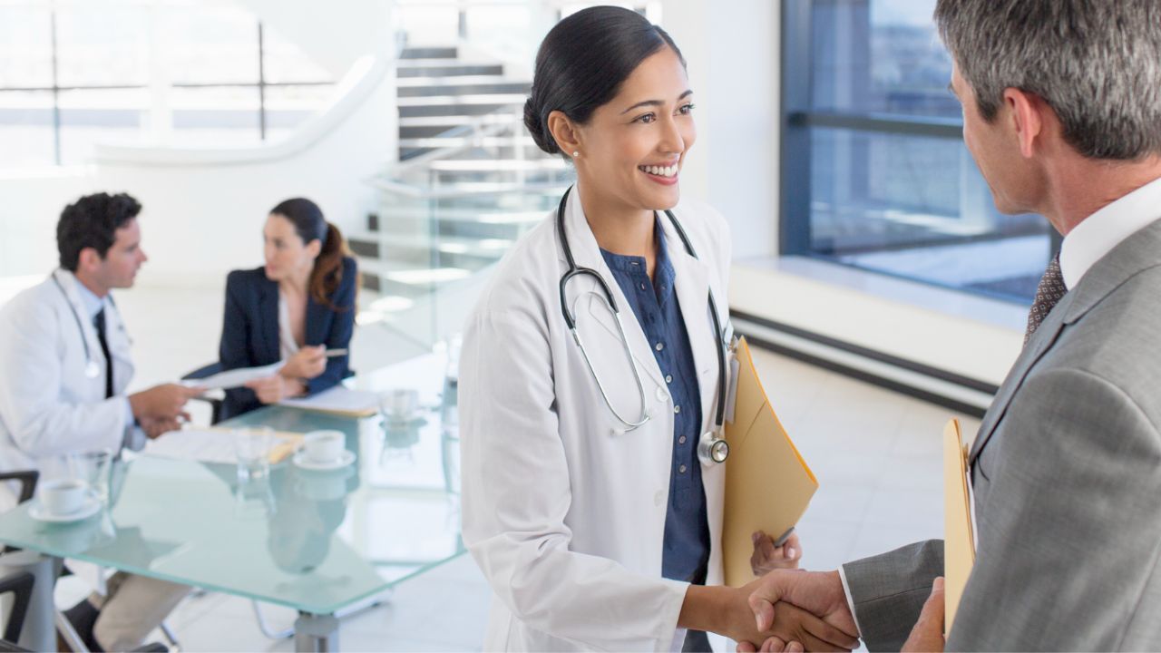 doctor shaking hands with business person