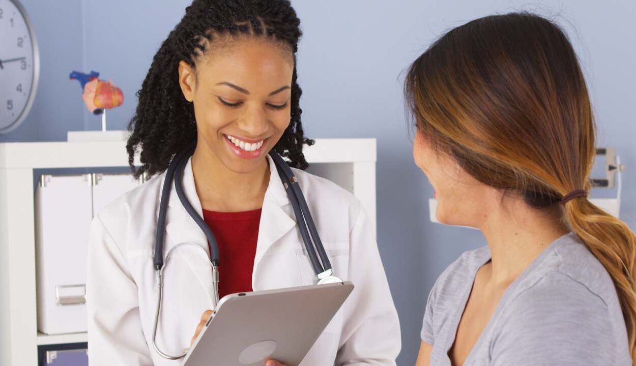 doctor talking with patient and looking at tablet