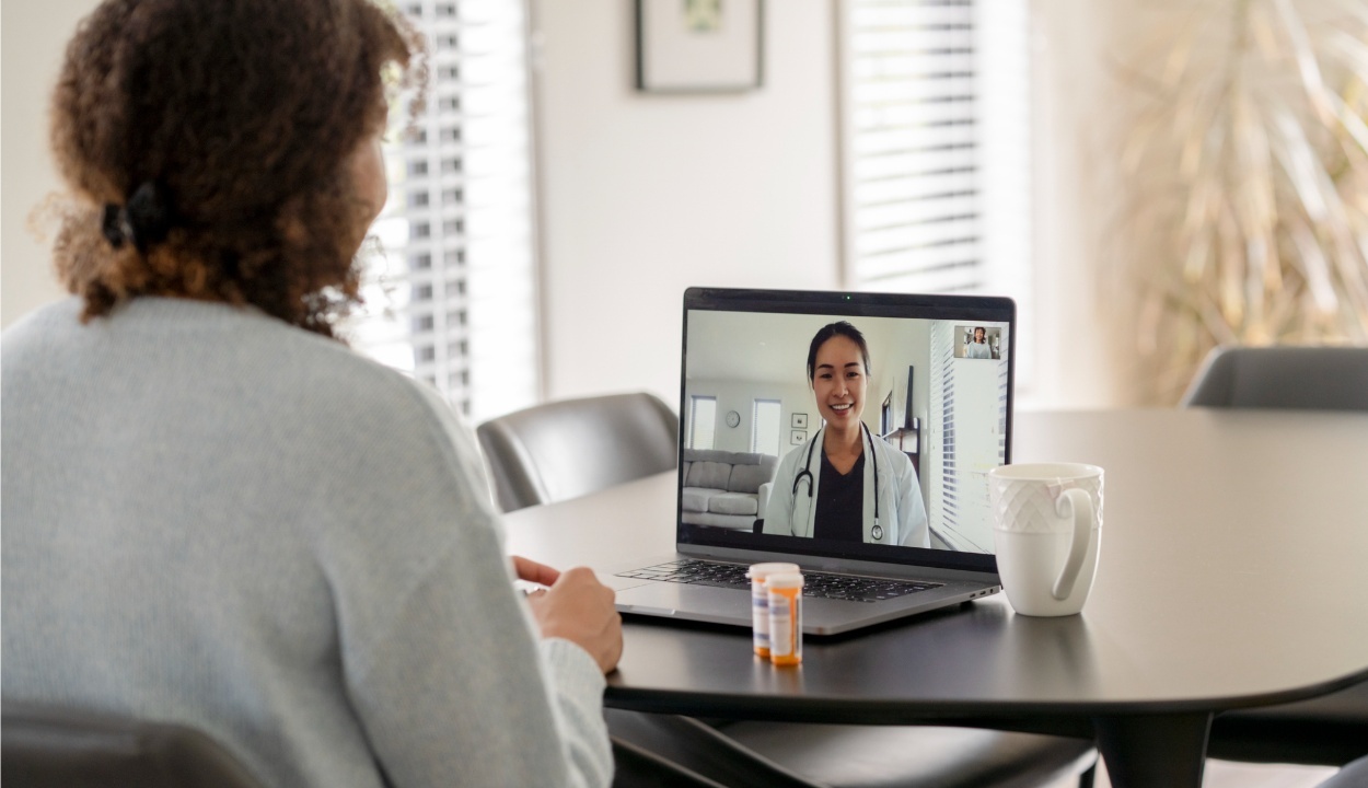 patient in front of a laptop screen talking with doctor